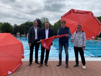 Zehn neue Sonnenschirme sponserte die Vereinigte Sparkasse im Märkischen Kreis dem Neuenrader Freibad.