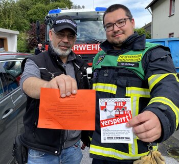 Feuerwehr und Ordnungsamt verteilen Hinweiszettel an Parkende, die die Restfahrbahnbreite nicht einhalten. 